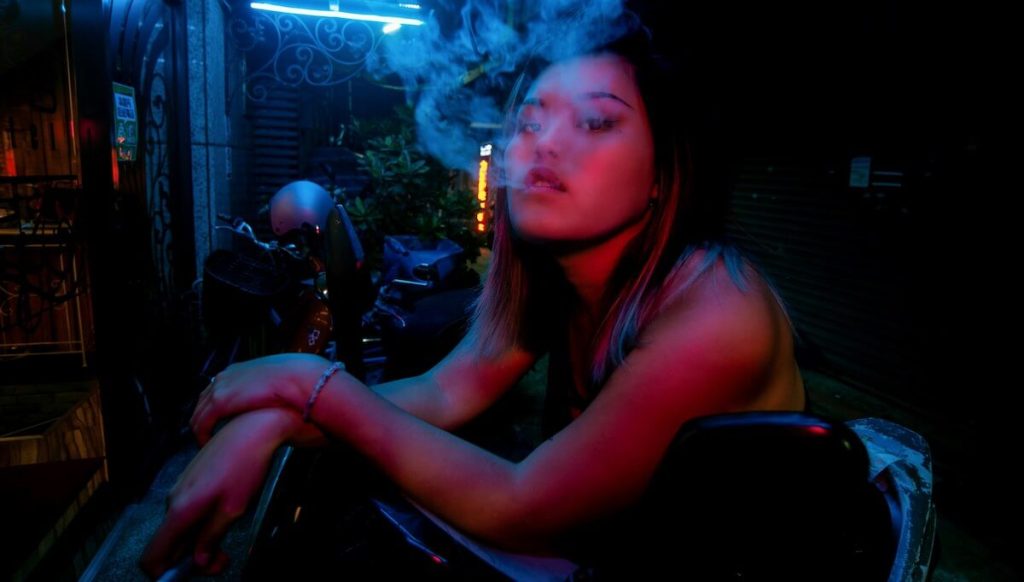 good looking women blows out smoke