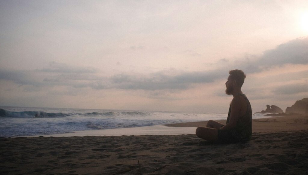 a man meditating on the beach
